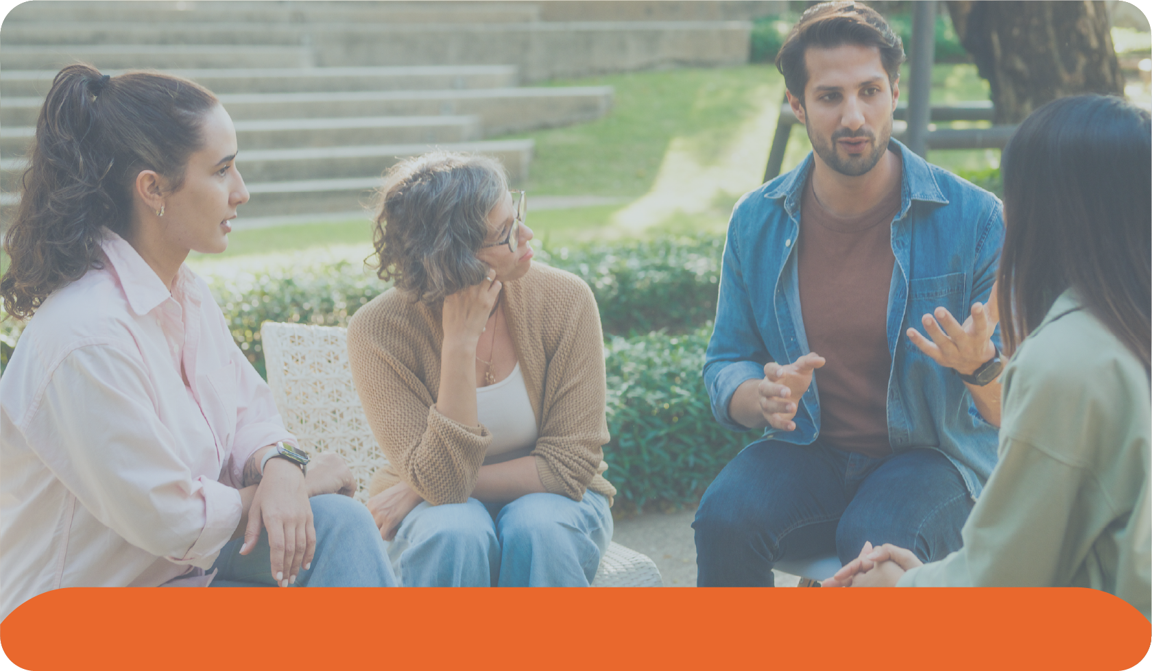 A group of young adults in open conversation outdoors