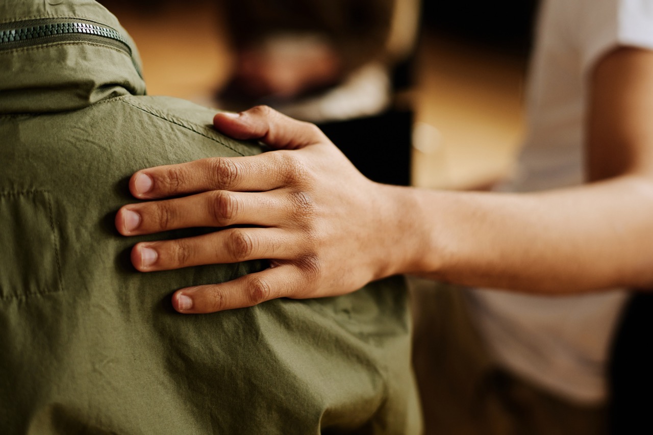 A hand resting reassuringly on someone’s shoulder