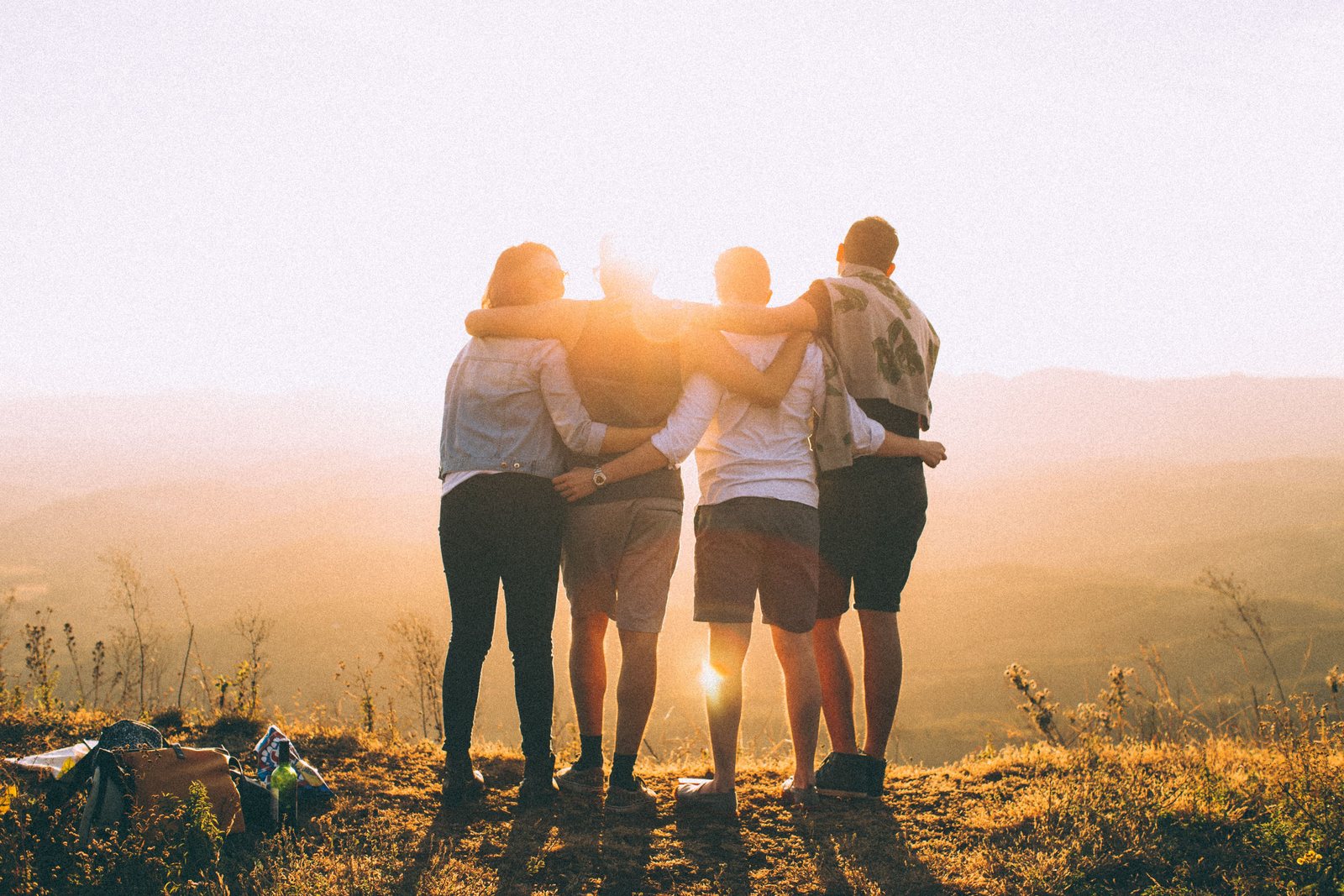Young friends with arms around each other, outdoors